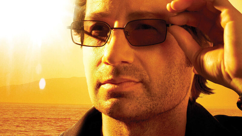 man adjusting sunglasses at sunset