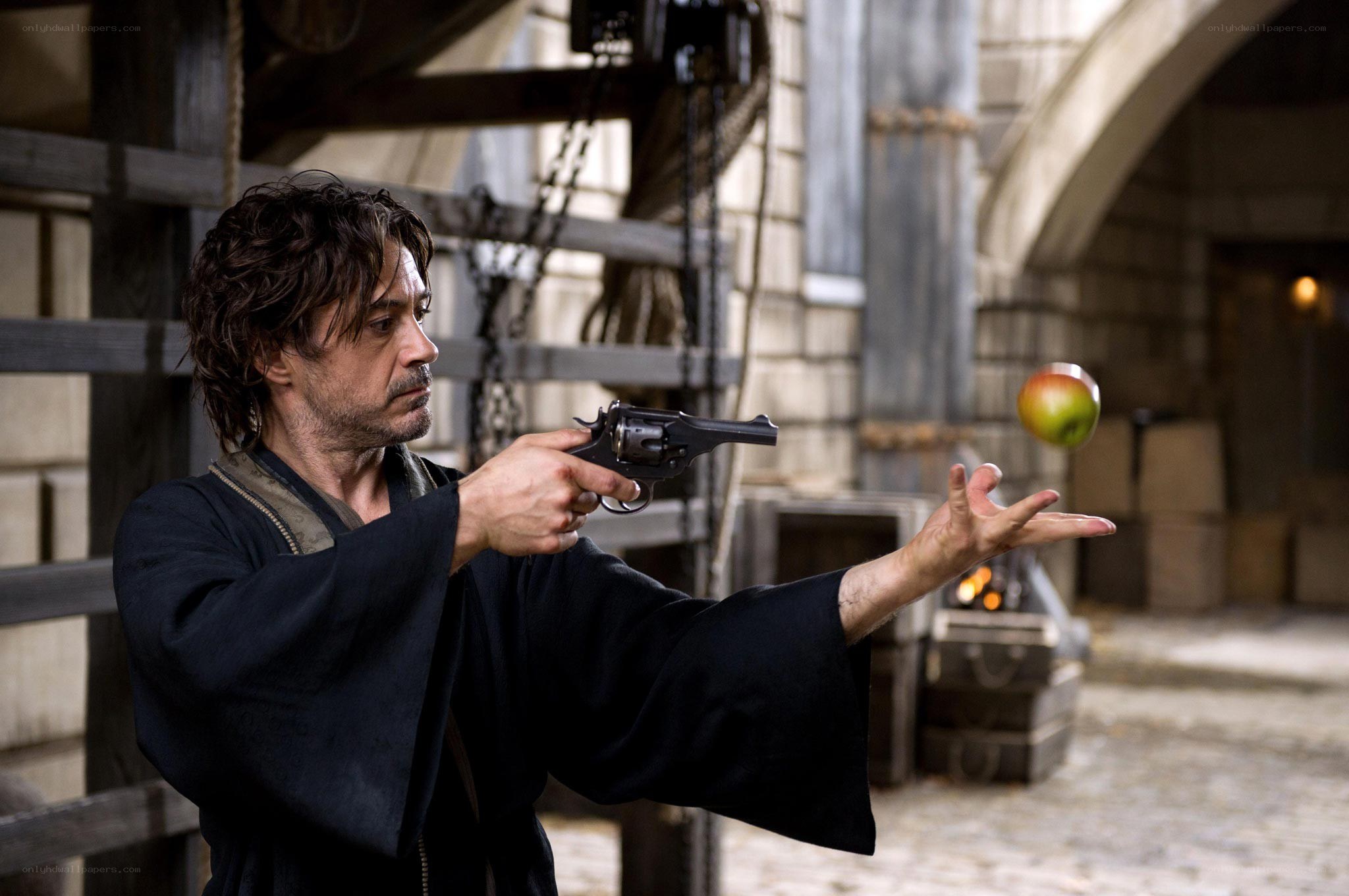 man aiming gun at apple