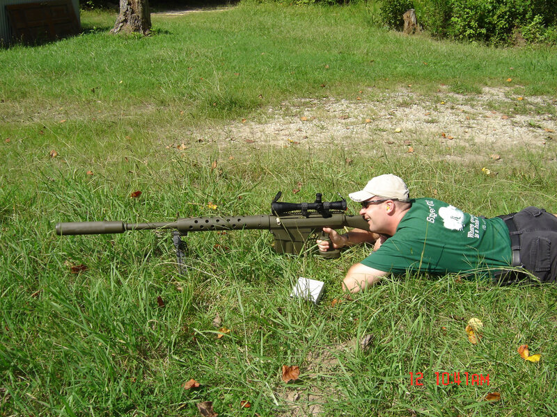 man aiming rifle in grass