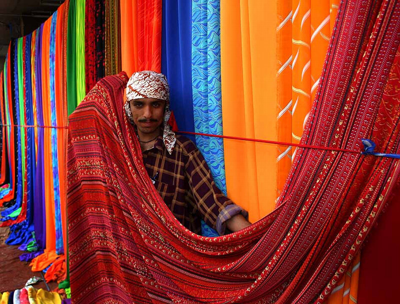 Man among colorful fabrics