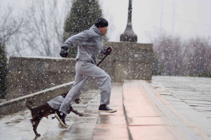 Man and dog running in snow