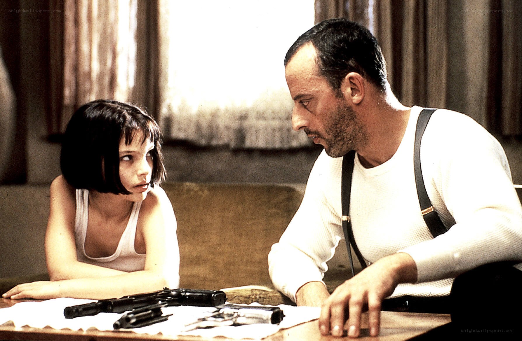 Man and girl at table with guns