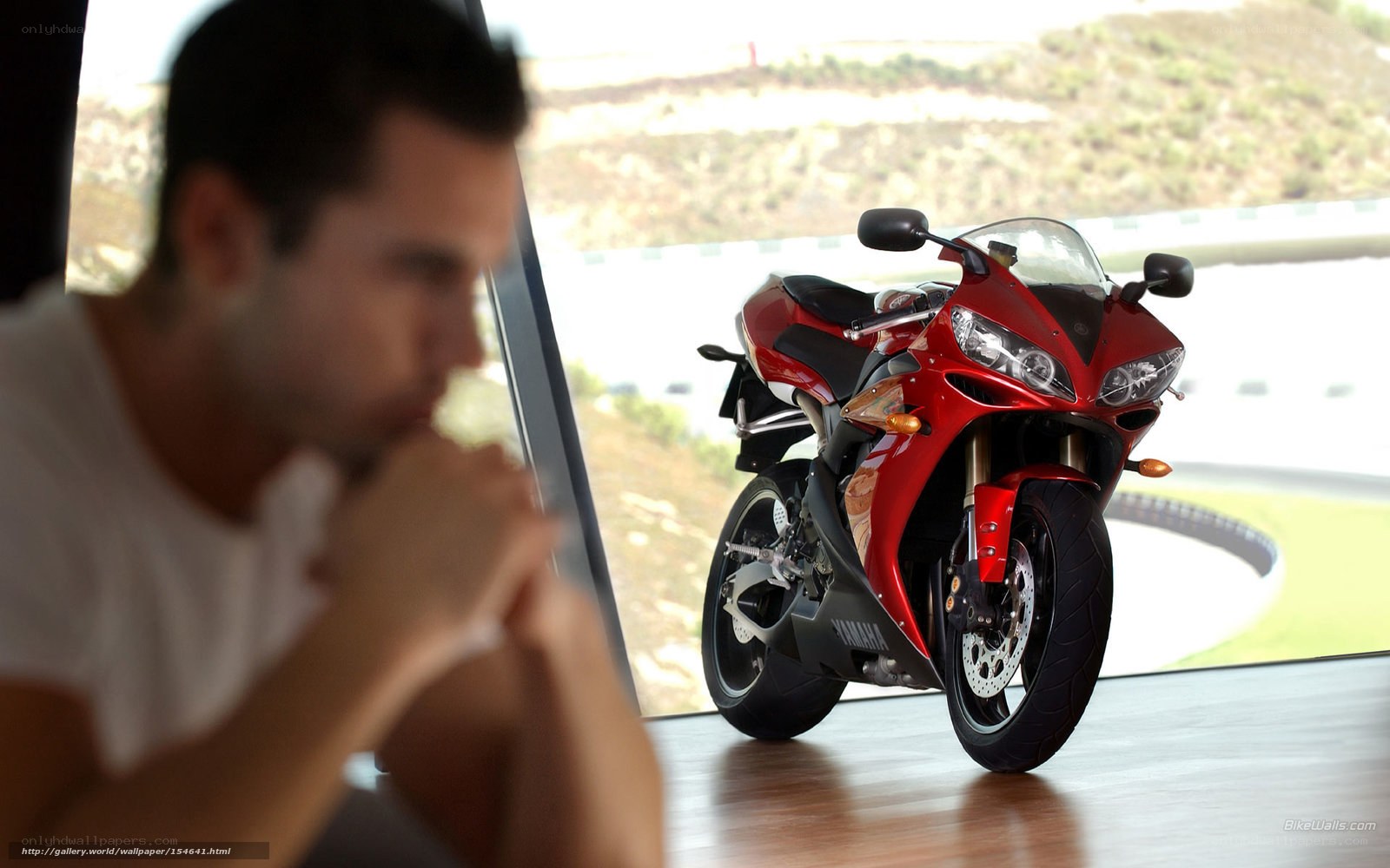 Man and red motorcycle indoors