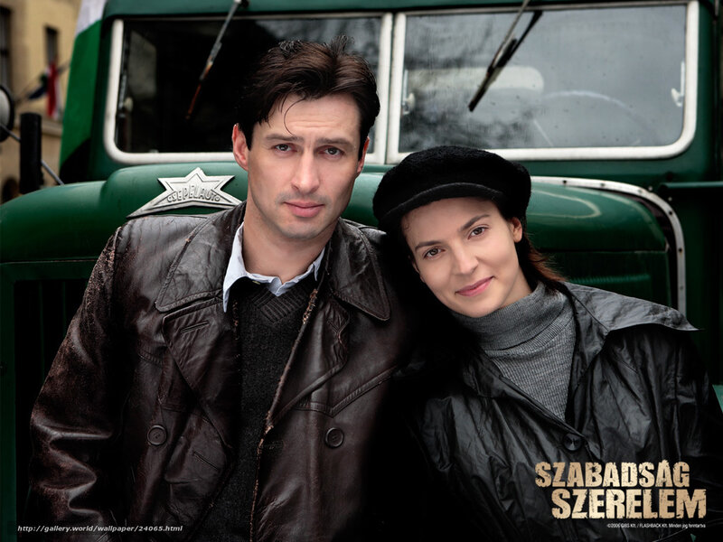 Man and woman in front of green truck