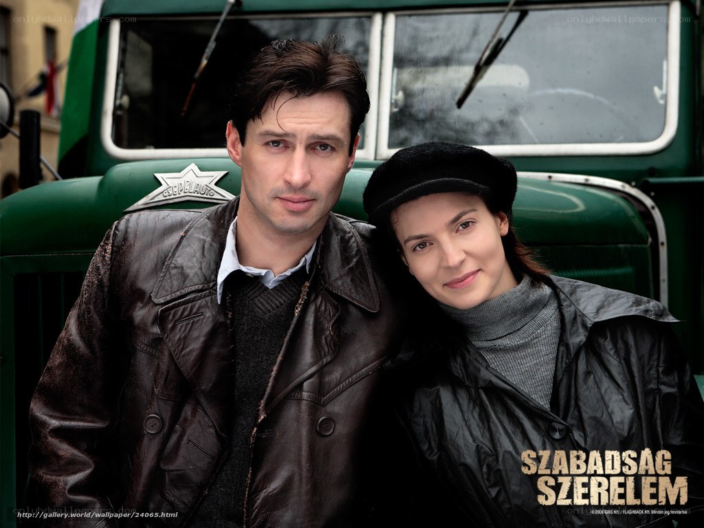 Man and woman in front of green truck