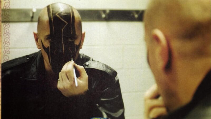 man applying face paint in mirror