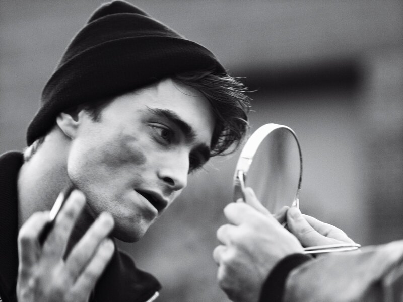 man applying makeup with mirror