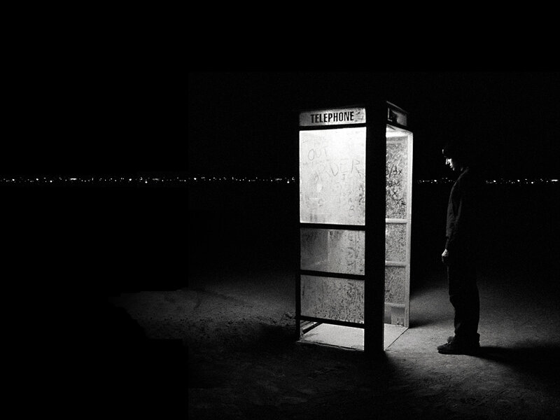 Man at a phone booth at night