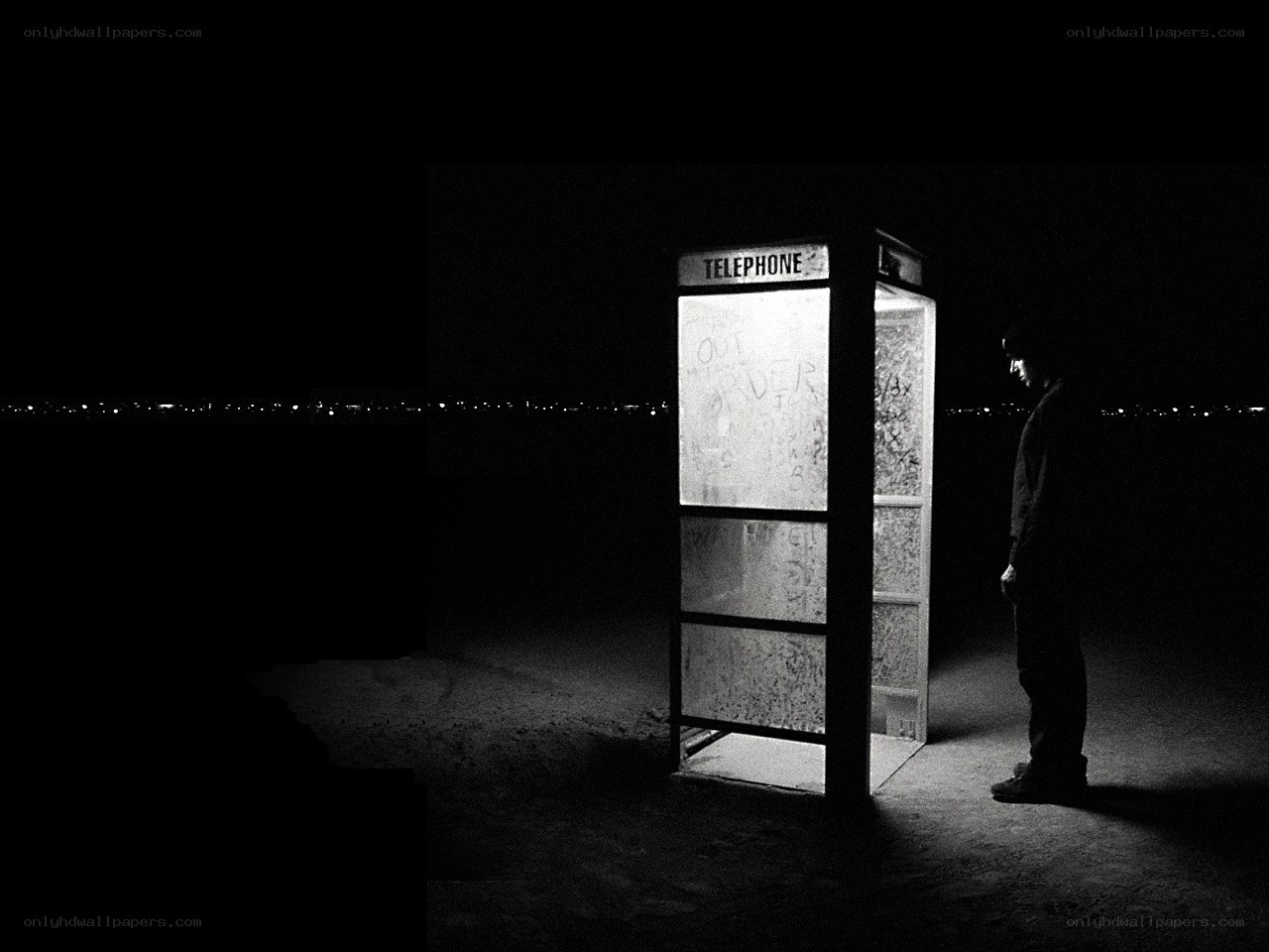 Man at a phone booth at night
