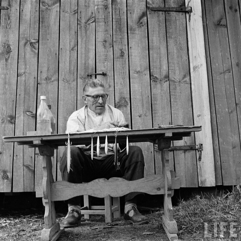 Man at a wooden table with fishing lures