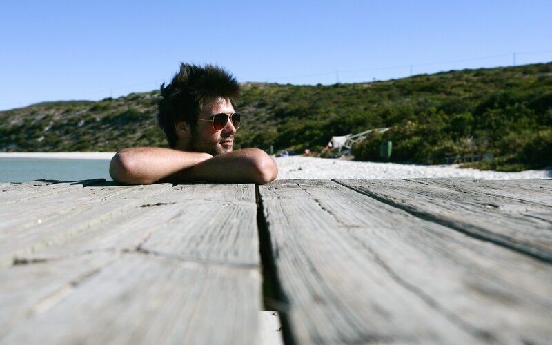 Man at beach on wooden pier