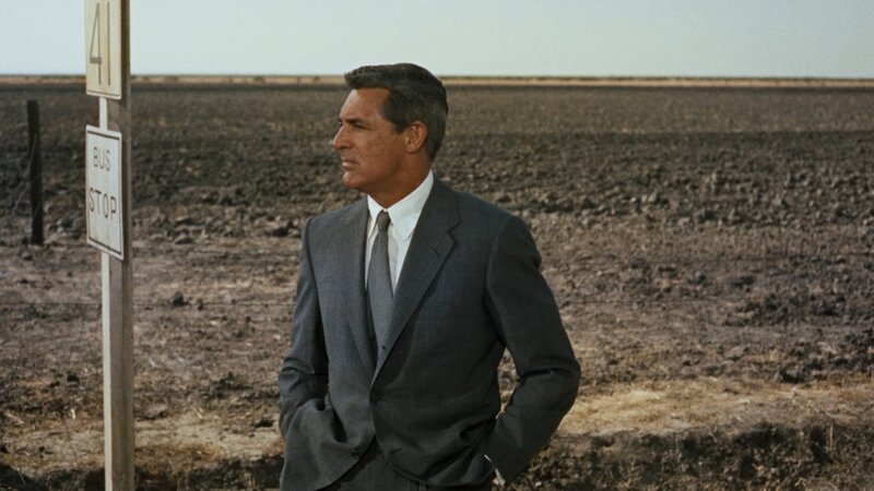 Man at bus stop in desert