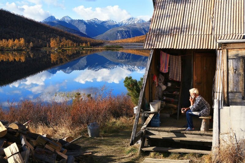 Man at cabin by mountain lake