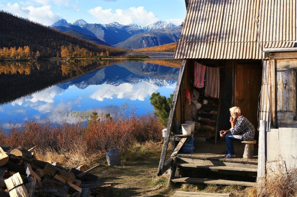 Man at cabin by mountain lake