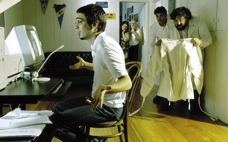 Man at computer with people behind