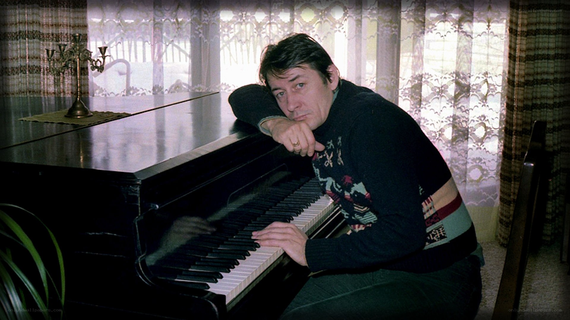 man at piano by window