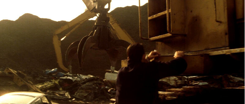 Man at scrapyard with crane
