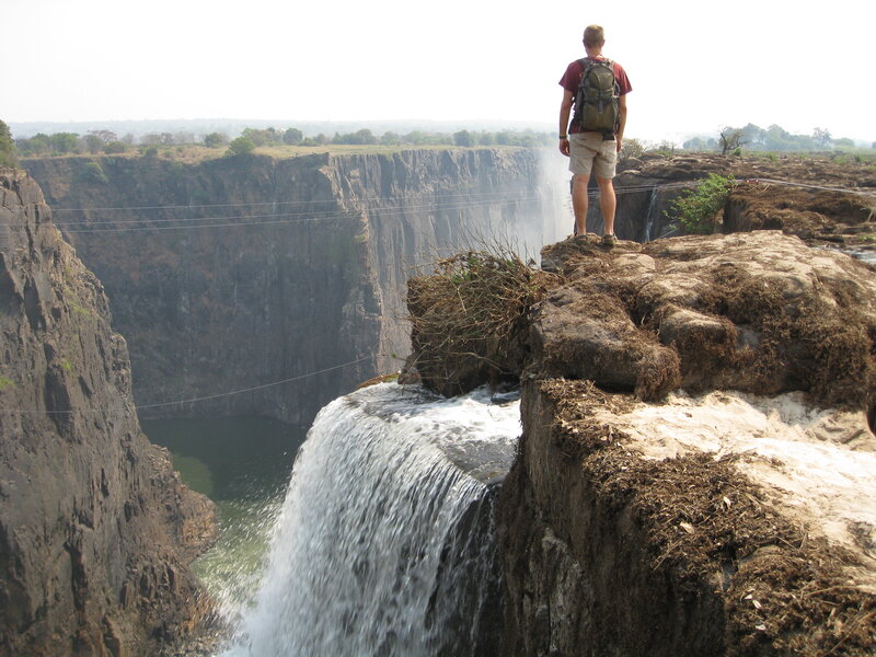 Man at Waterfall Edge — Brown
