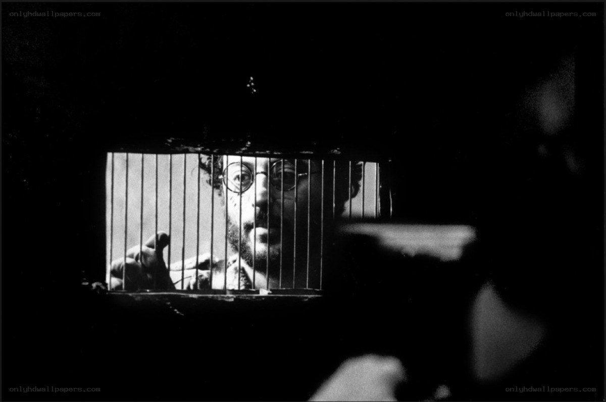 man behind bars in black and white