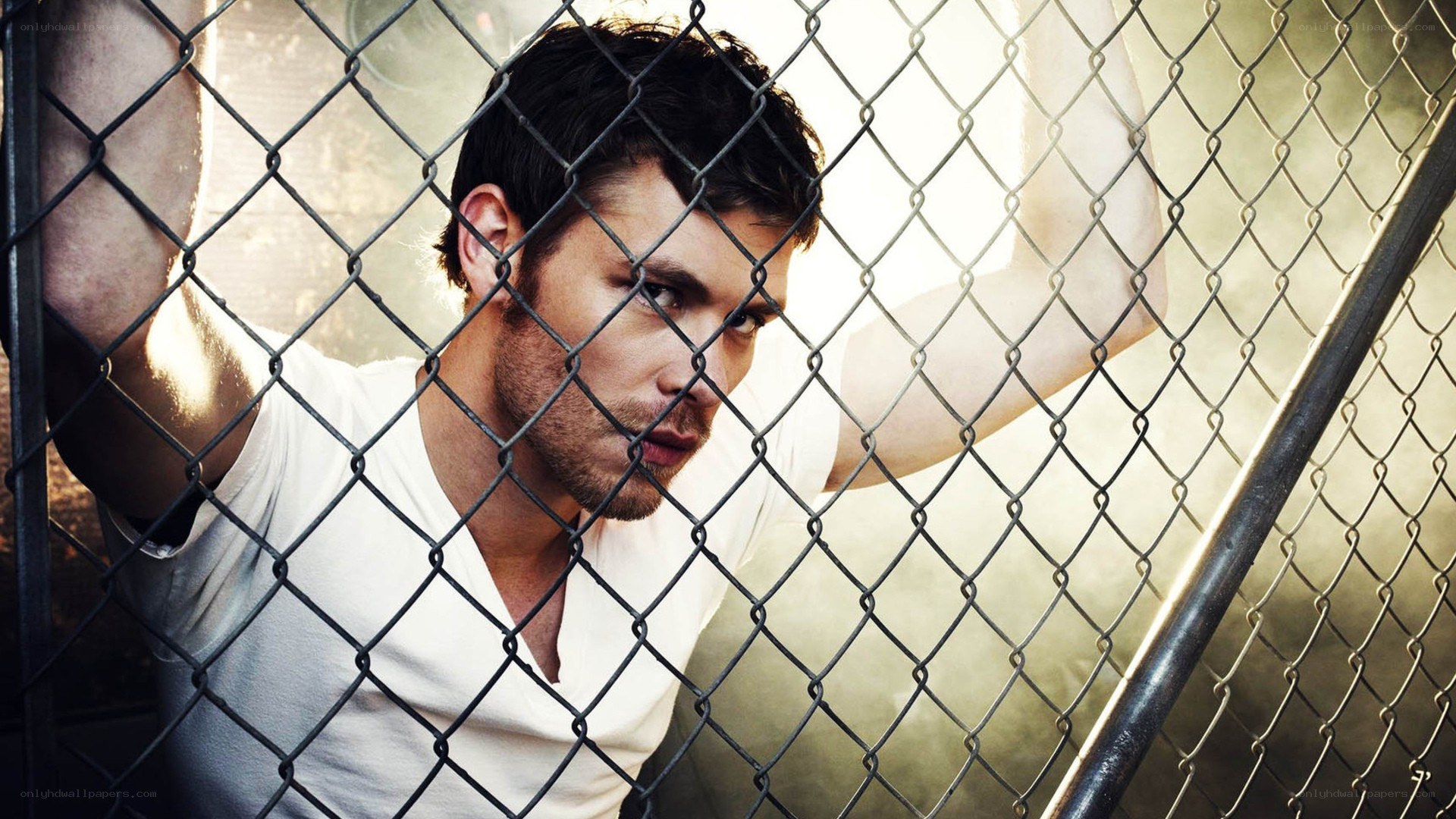 man behind chain-link fence