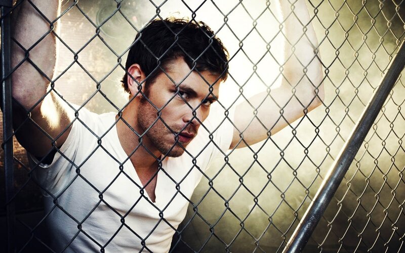 Man Behind Chain-link Fence — Black, Dramatic, Photograph