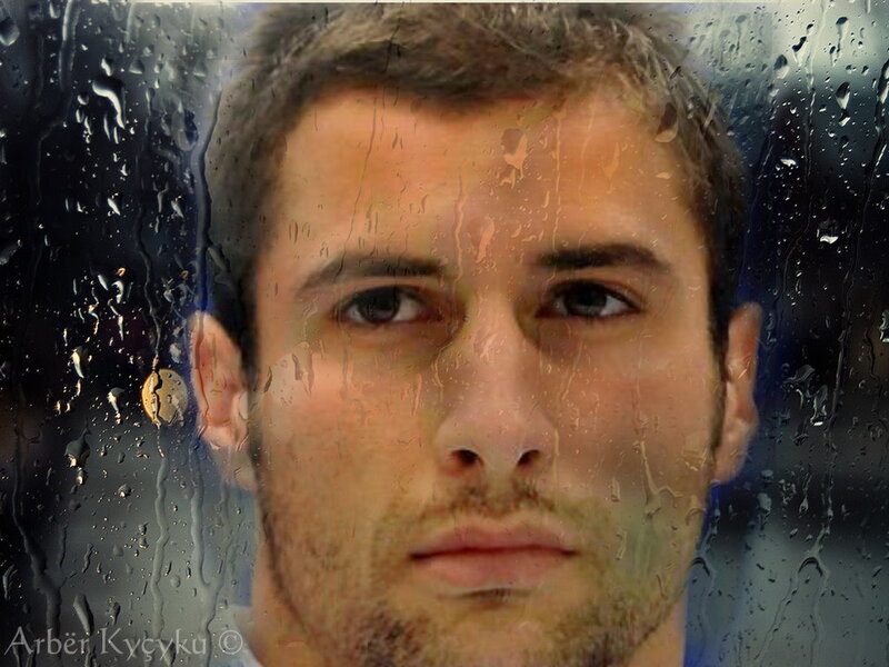 man behind rain-streaked glass