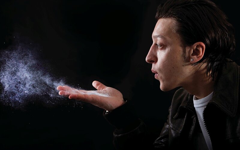 man blowing powder from hand