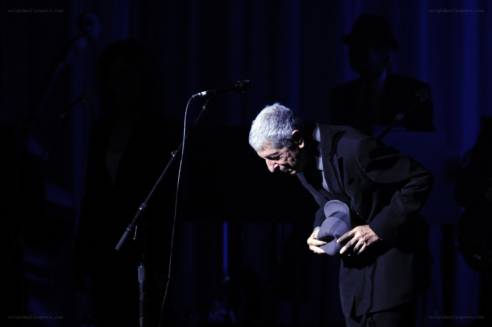 Man bowing on stage with hat