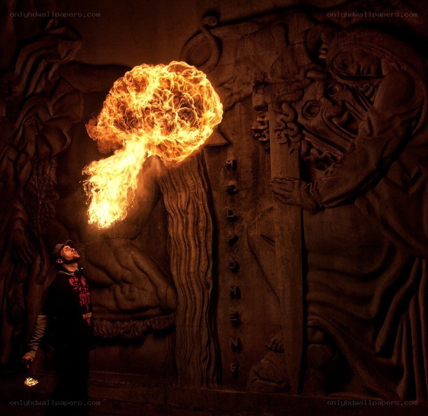 Man breathing fire in a dark hall