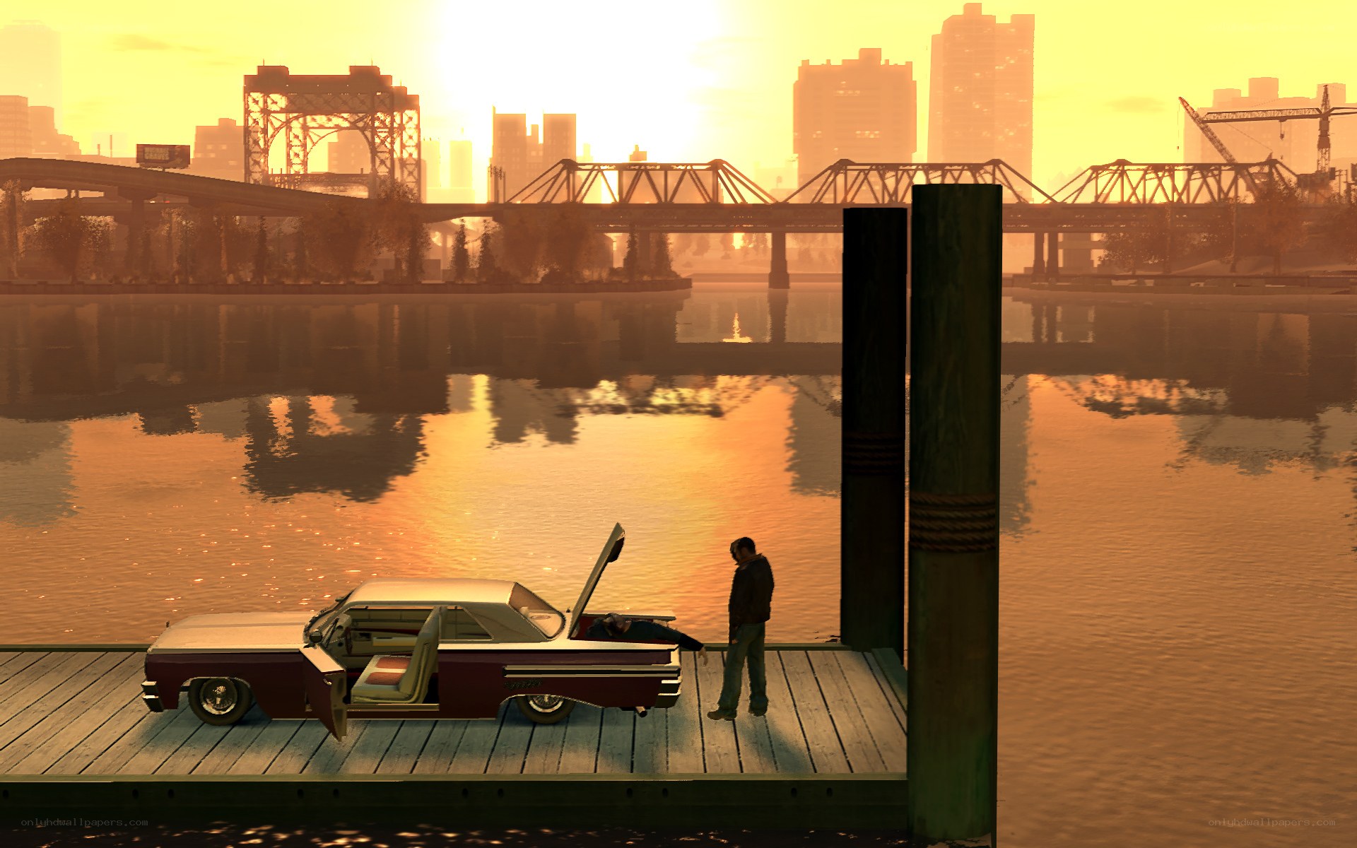 Man by car on dock at sunset