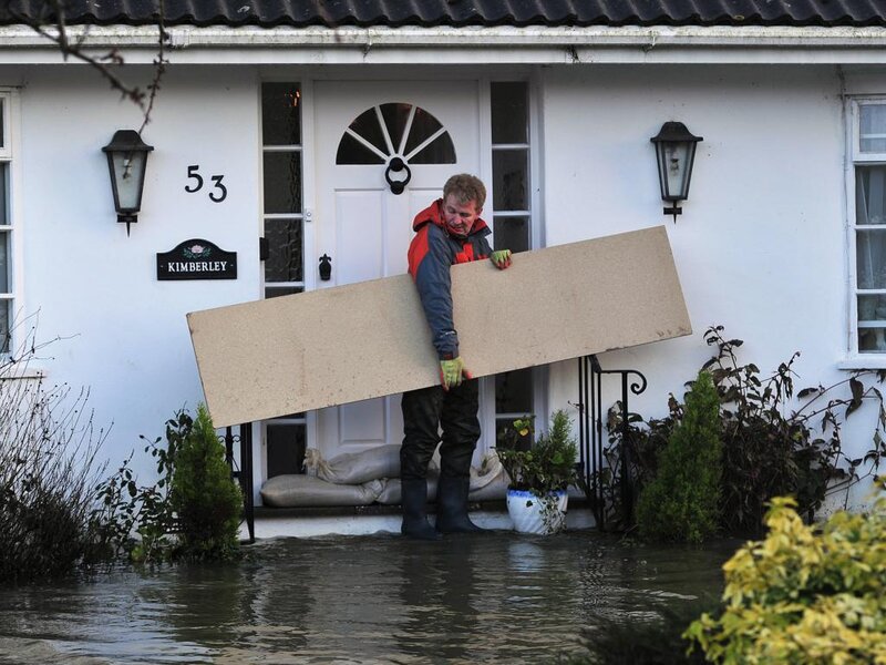 Man Carrying Board in Flood
