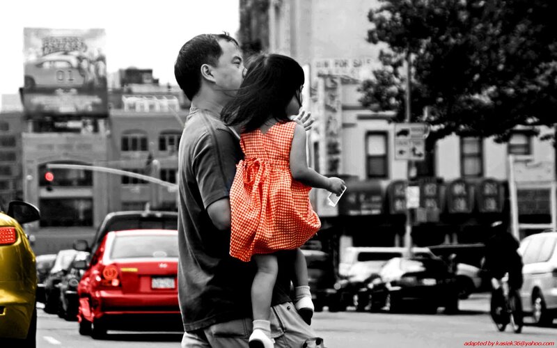 man carrying child in city