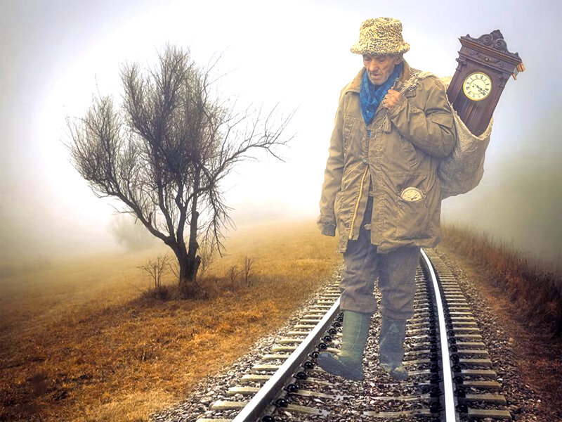 Man Carrying Clock on Train Tracks