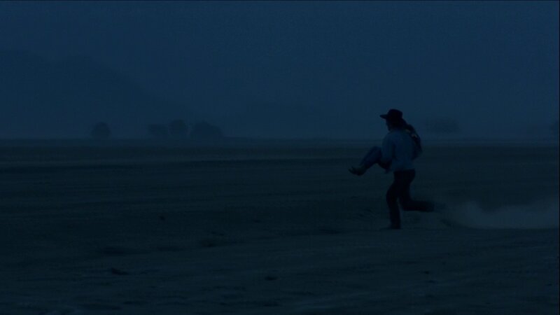 man carrying person in dark field