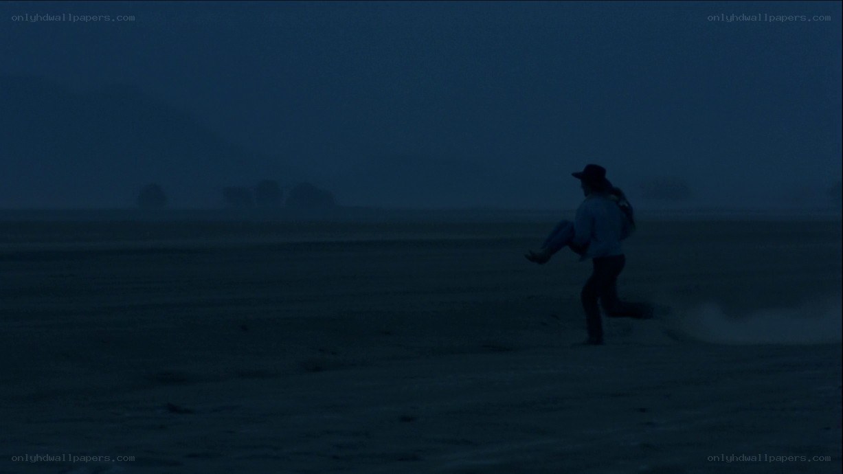 man carrying person in dark field