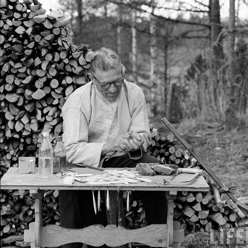 Man carving wood outdoors