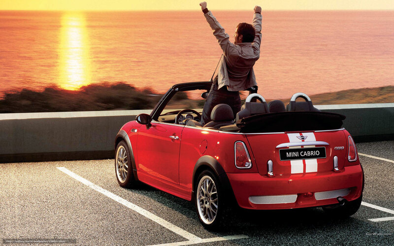 Man celebrating in red convertible