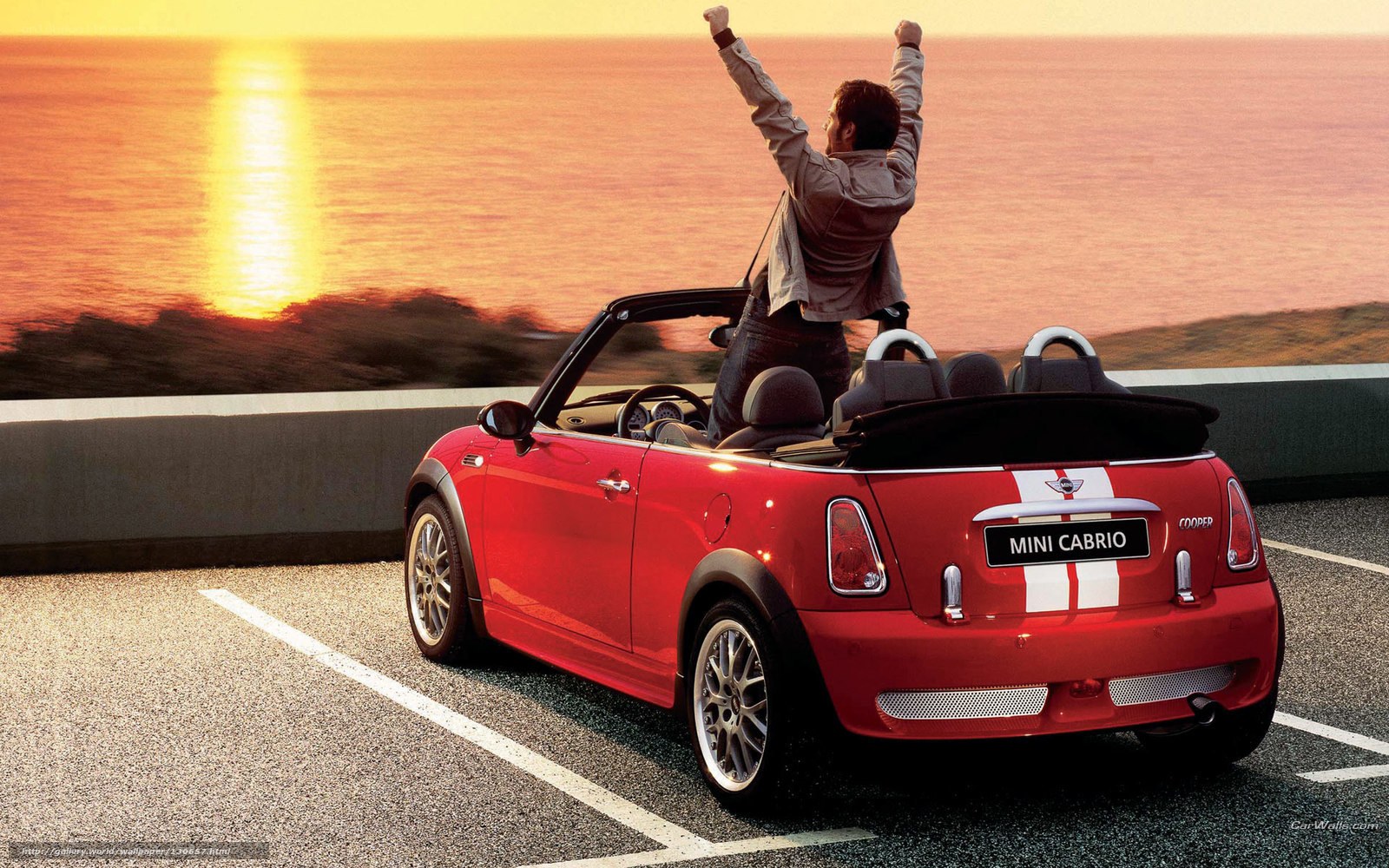 Man celebrating in red convertible