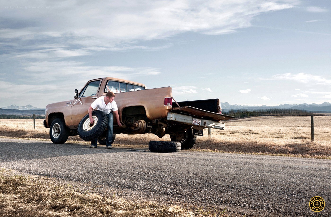 man changing tire on pickup truck