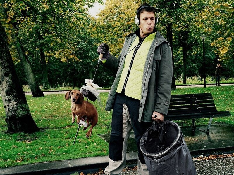Man cleaning park with dog