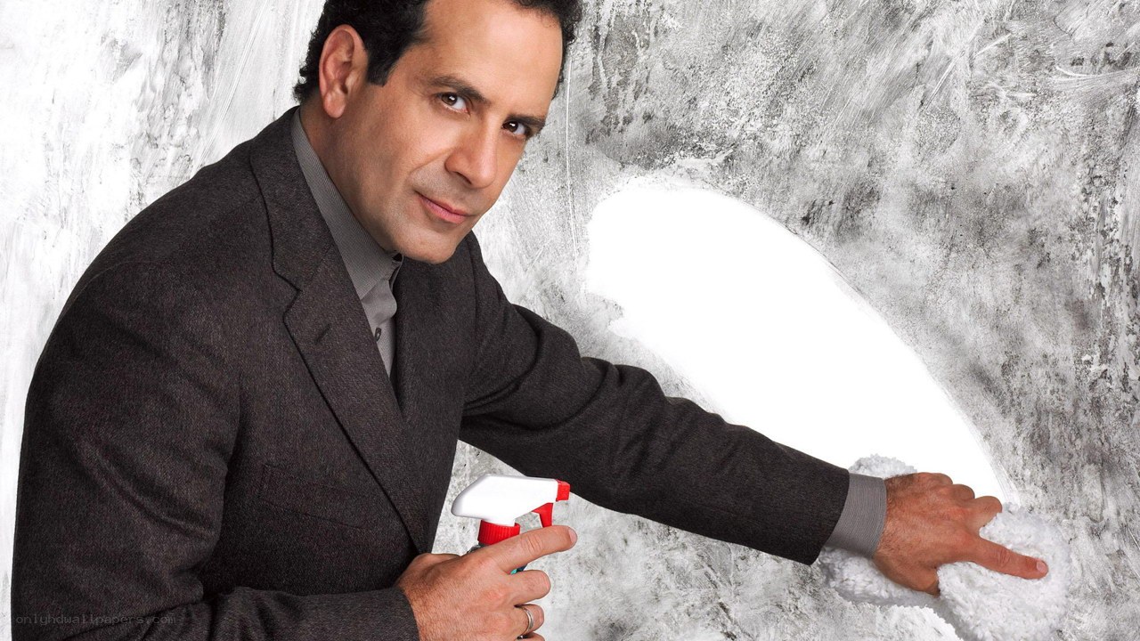 man cleaning wall with spray