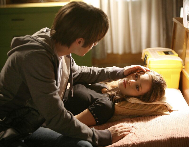 man comforting woman on bed