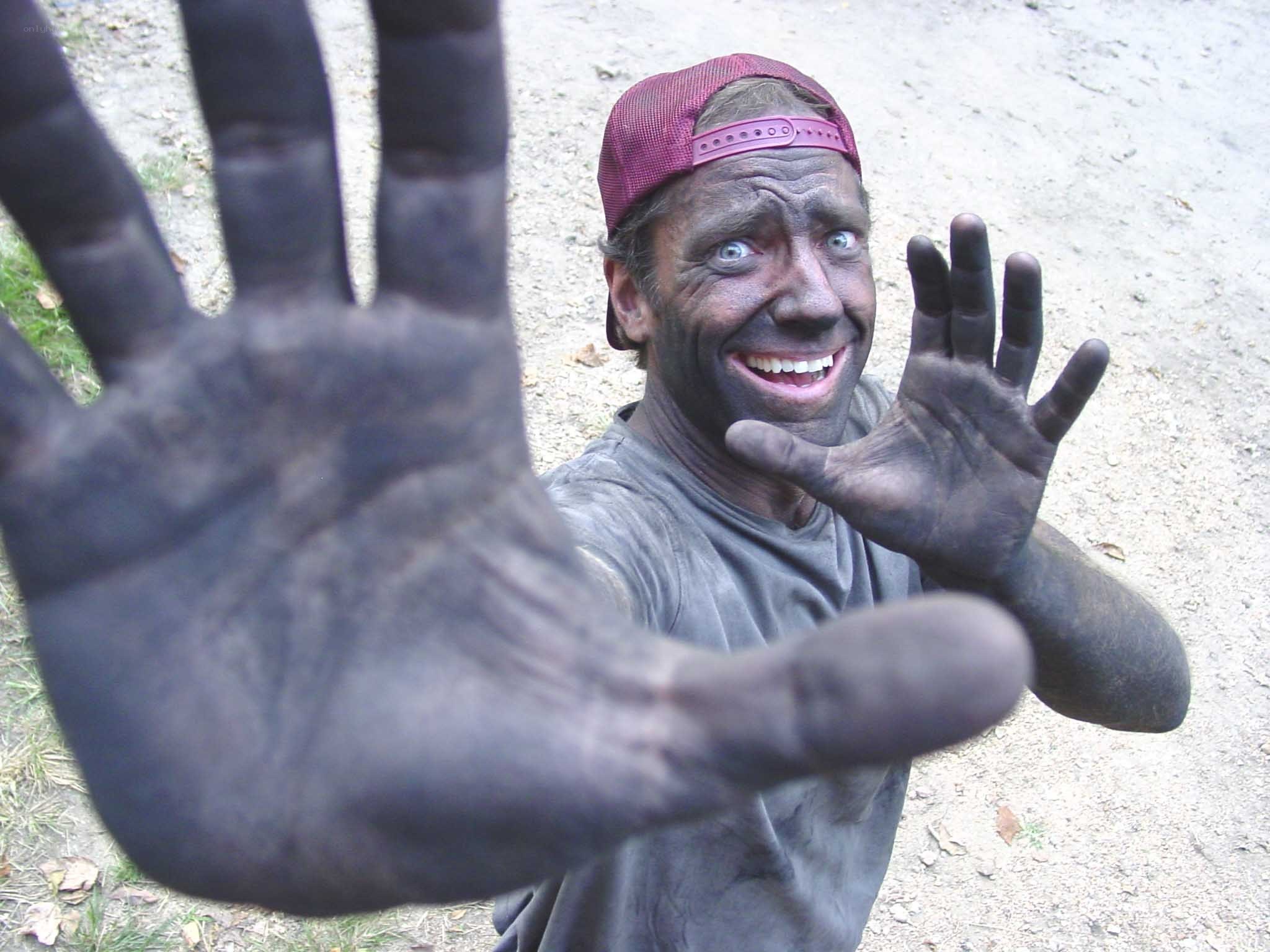 man covered in black soot