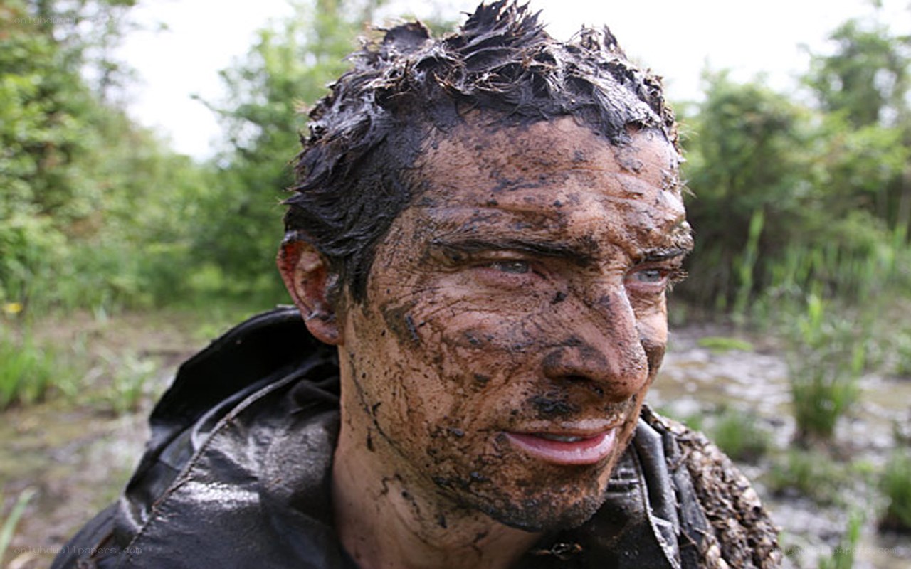 man covered in mud outdoors