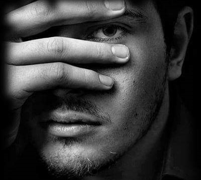 Man Covering Eye with Hand