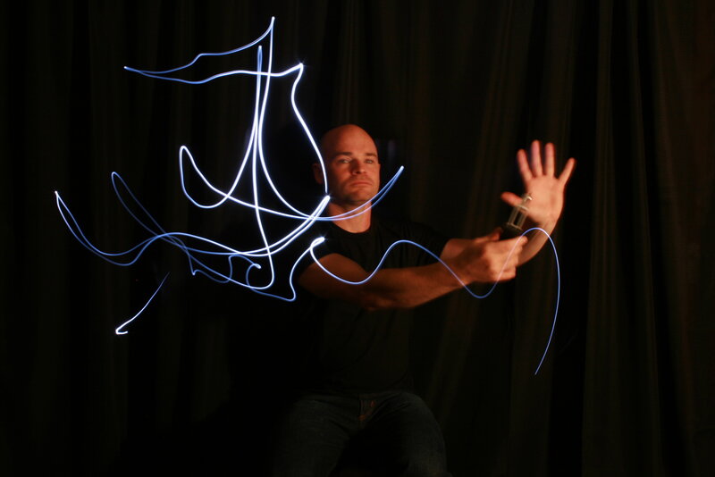 man creating light art