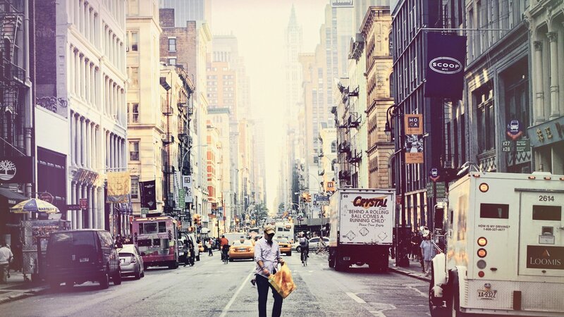 Man crossing a busy city street