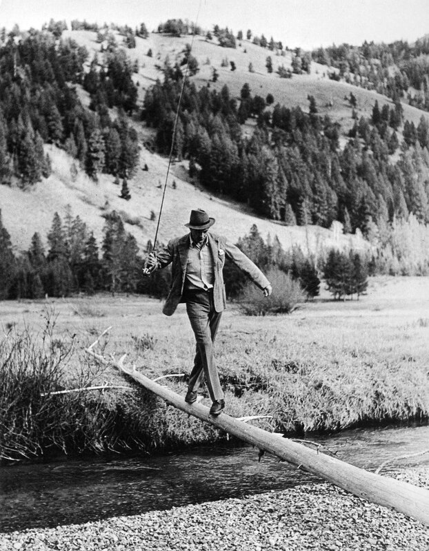 Man crossing river on log