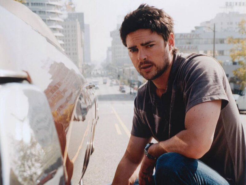 Man Crouching by Car