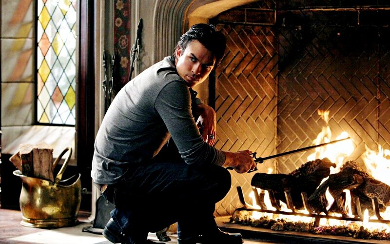 Man Crouching by Fireplace